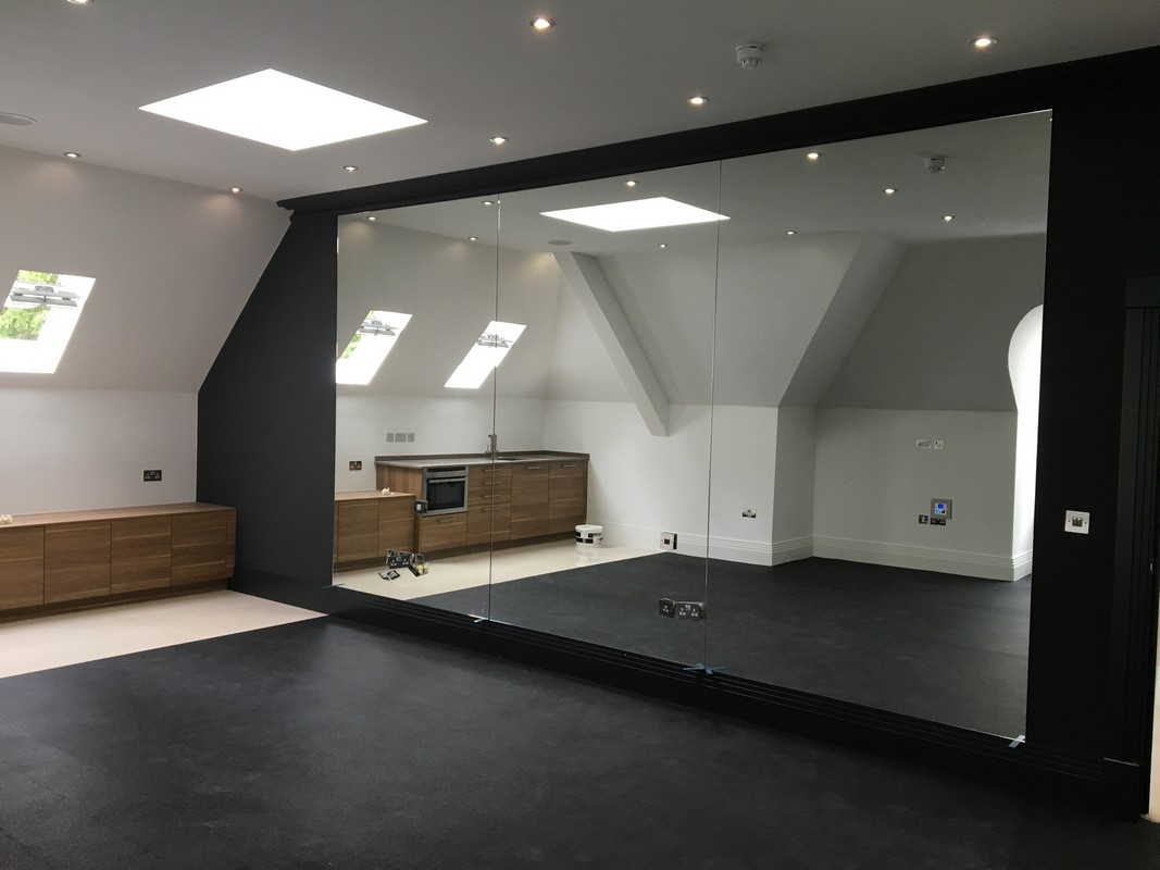 Frameless glass wall dividing loft conversion in Barnes